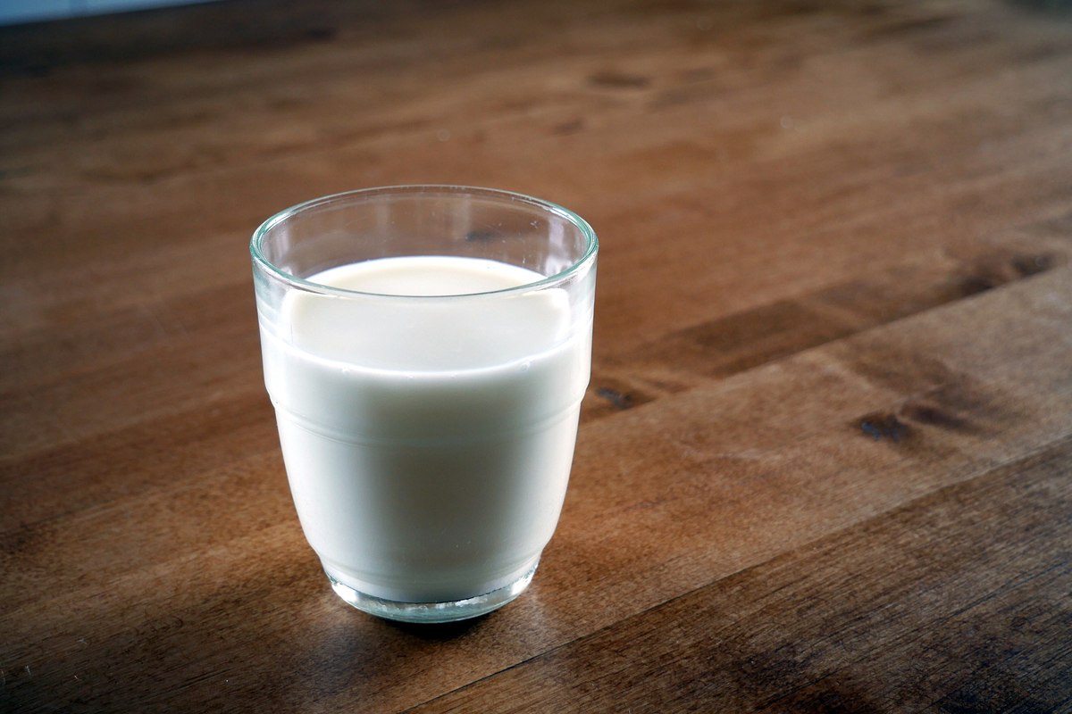 A clear glass filled with milk on a kitchen counter.